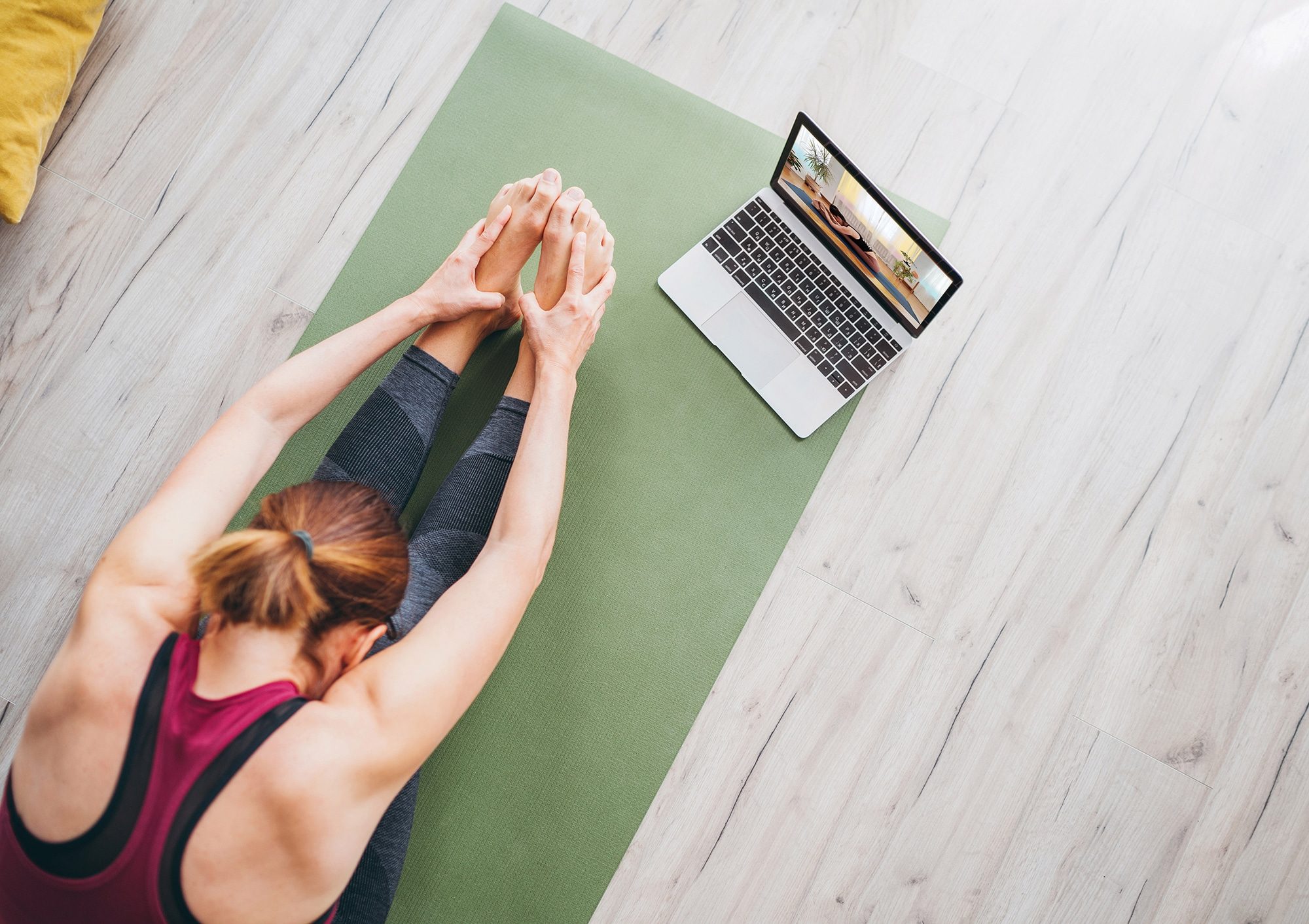 Fit sporty healthy woman sitting on mat in Paschimottanasana pos
