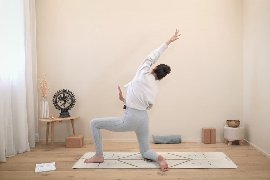 Insegnante di Nuvola Yoga in affondo basso con allungamento laterale durante una lezione di Hatha flow open